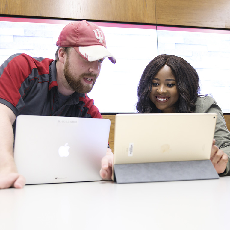 UITS Support Center staff member assisting a student on a tablet