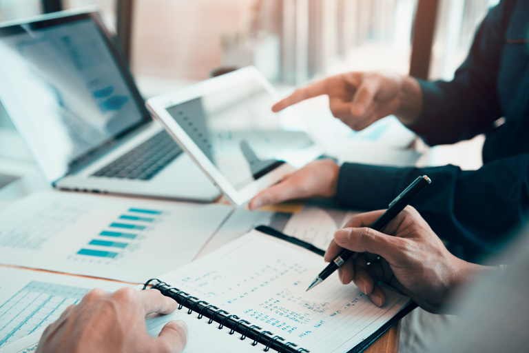 Two individuals reviewing finance information and graphs